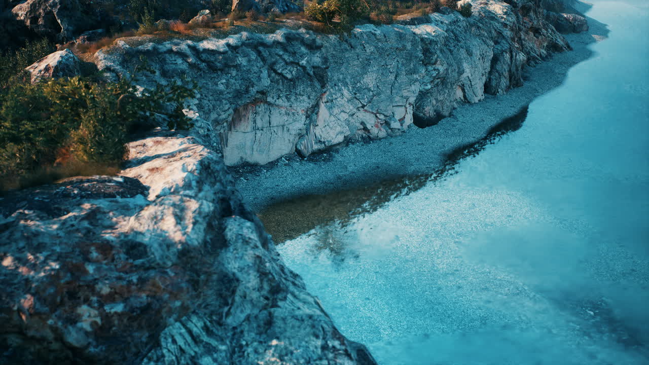 vista aérea de una orilla rocosa y un río tranquilo