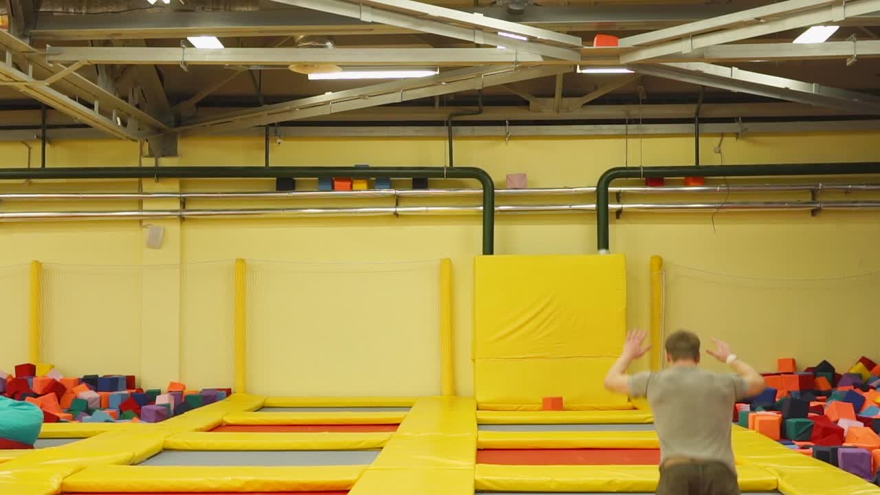 어린이 들 과 성인 들 이 트램폴린 공원 에서 재미 를 느끼고 있다