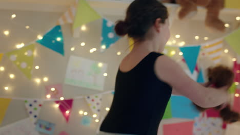 una adolescente feliz bailando en la cama con un tutu de ballet divirtiéndose bailando con un oso de peluche en el dormitorio