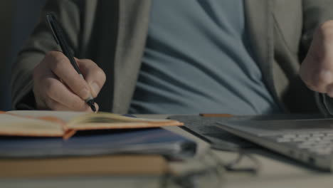 persona que trabaja en un escritorio con una computadora portátil y un cuaderno