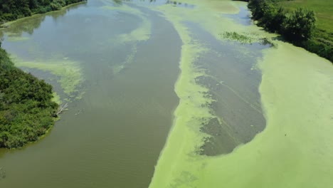 flying low over dirty looking water revealing a nice landscape at end