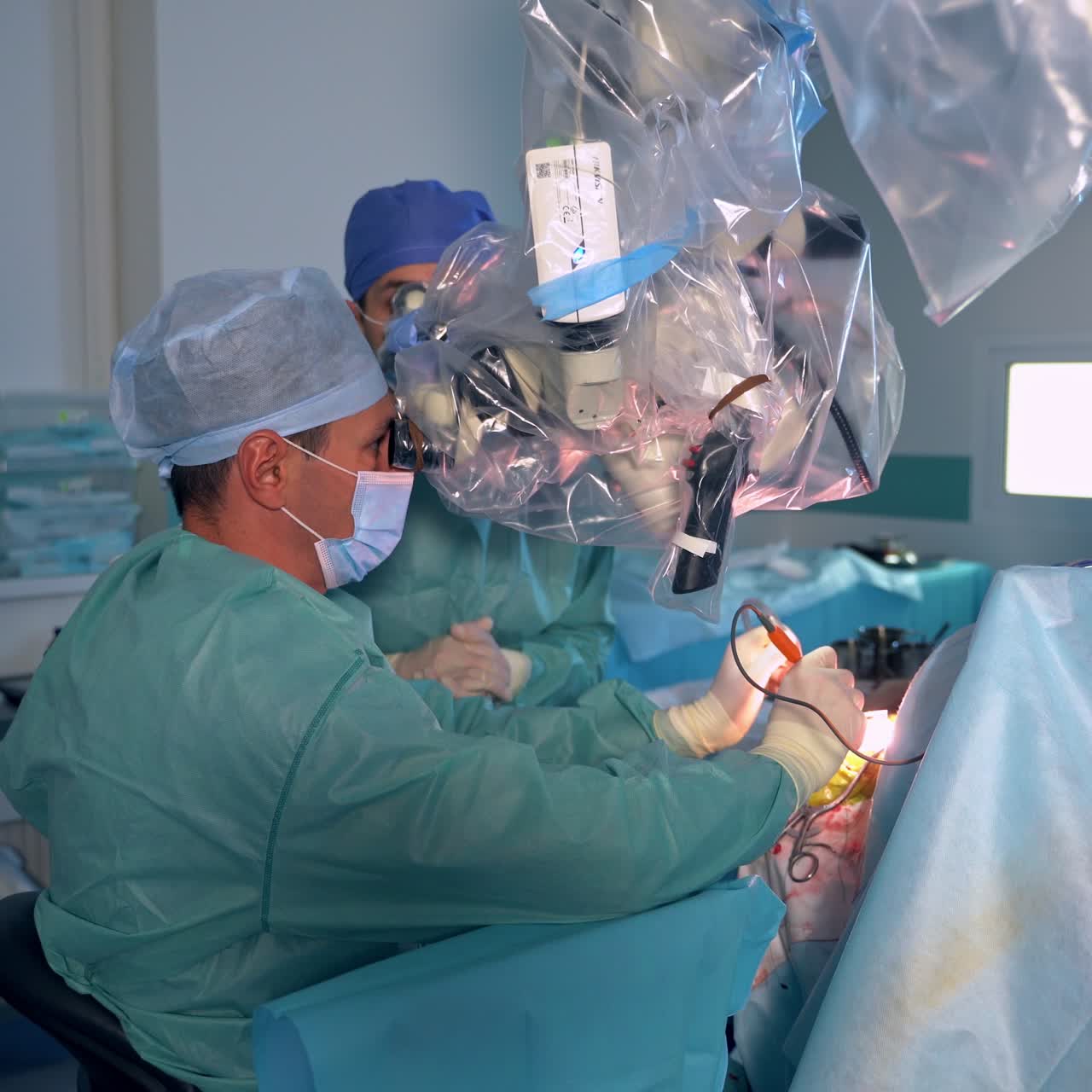 Professional surgeons sit near the operated patient. Long operation conducted in the modern surgery theatre