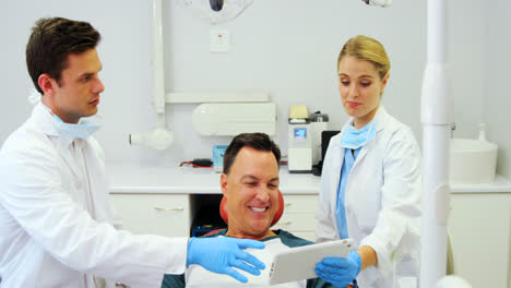 dentists showing dental report on digital tablet