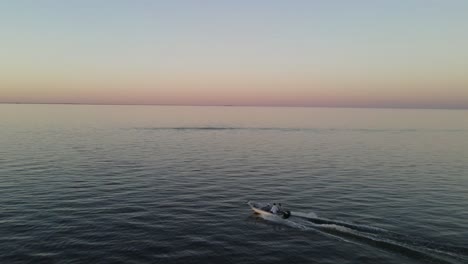 people speeding across the waves in sunset -aerial