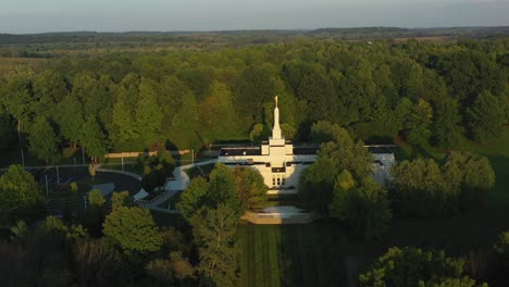 pull back drone shot of the palmyra temple near the joseph smith family farm, frame house, visitors center, sacred grove in palmyra new york origin locations for the mormons and the book of mormon