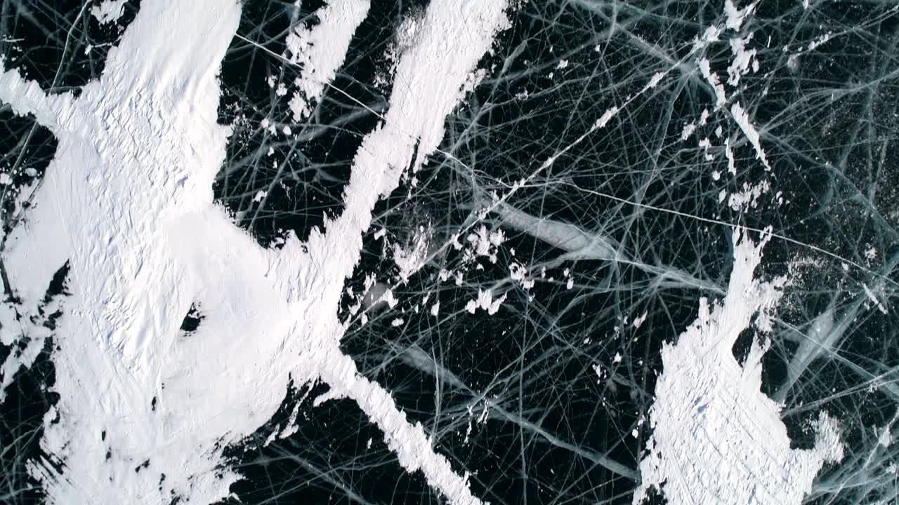 내부에 균열과 거품이있는 파란색 투명한 은 얼음 위의 공중. 얼어붙은 베이칼 호수. 자연 랜드마크. 겨울 풍경. 인기있는 관광지. 위에서 아래로 볼 수 있습니다.