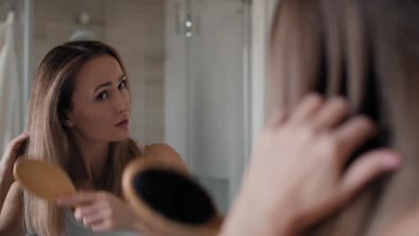 Mujer-Caucásica-Cepillándose-El-Cabello-En-El-Baño.