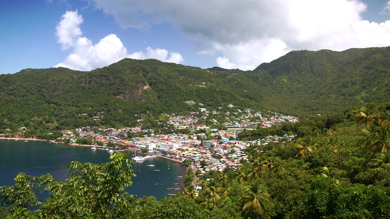 Splendida vista panoramica della Baia di Soufrière a Santa Lucia, con il colorato villaggio, la vegetazione tropicale e la montagna Piton che modella l'orizzonte lungo il Mar dei Caraibi