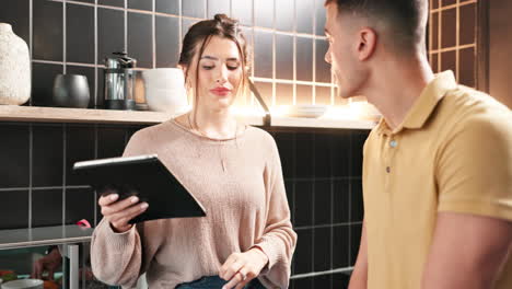couple cooking together in the kitchen using a tablet