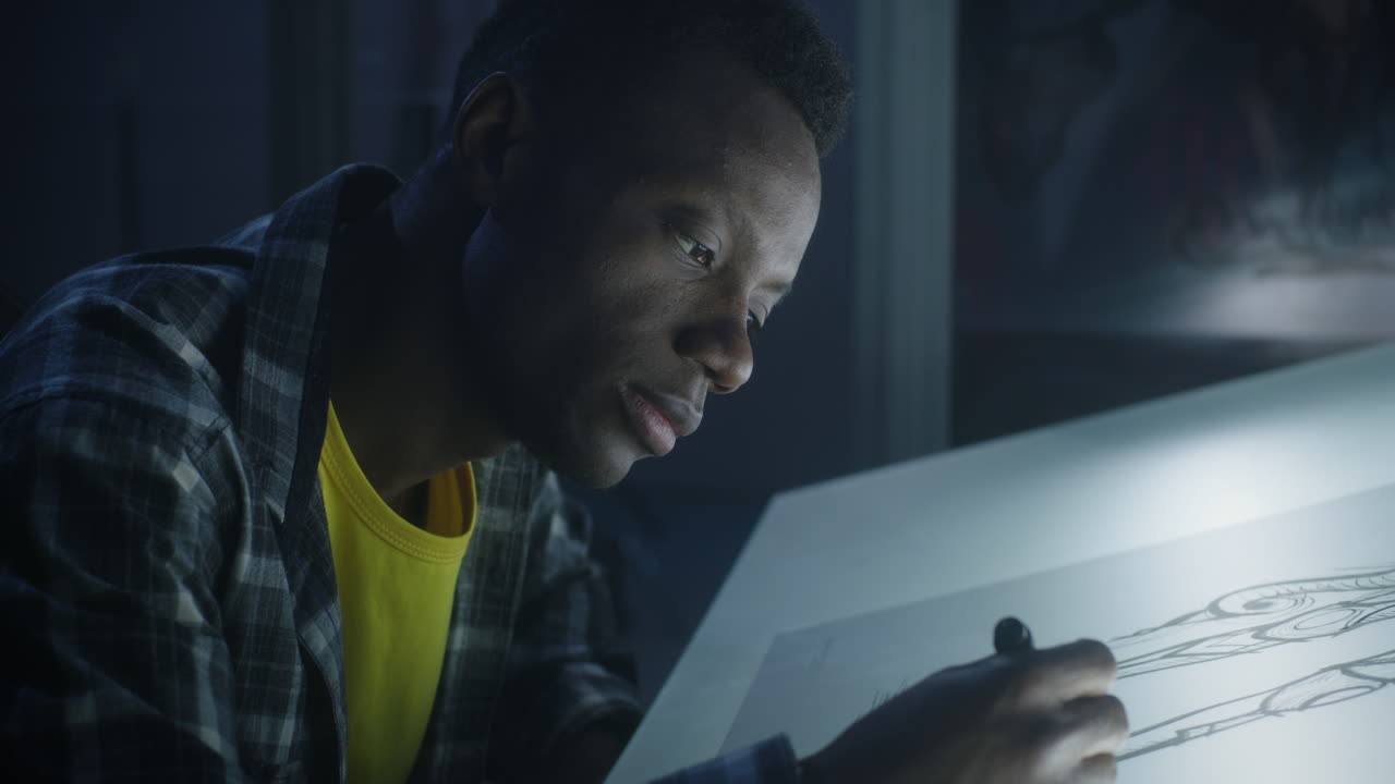 Artist drawing on drawing table at night