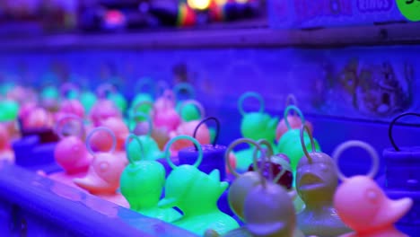 a group of plastic ducks floating by in the game hook-a-duck at the playfair attraction kiosk - close static view