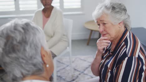 Diverse-group-of-senior-friends-giving-support-to-caucasian-female-friend-on-meeting