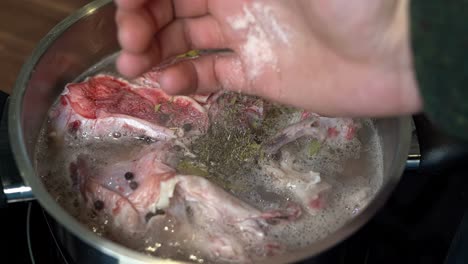 sal de roca rosada añadida a la sartén para cocinar caldo de huesos de res, cerrar la cámara lenta
