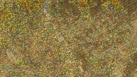 tela brillante brillante con pañuelos de primer plano. confeccionando ropa festiva. fondo brillante dorado. concepto de coser vestido de año nuevo