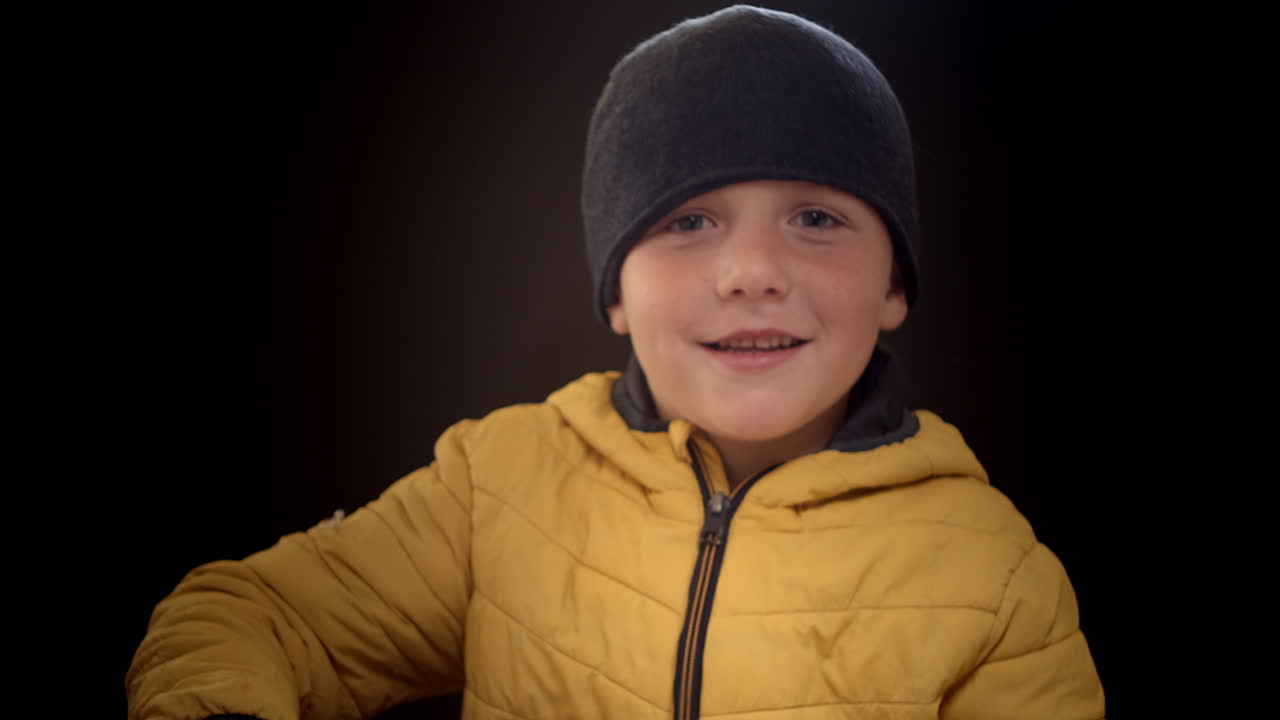 Smiling young boy puts on a homemade space helmet, close-up