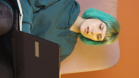 el video vertical de una mujer joven mirando una computadora portátil es reflexivo.