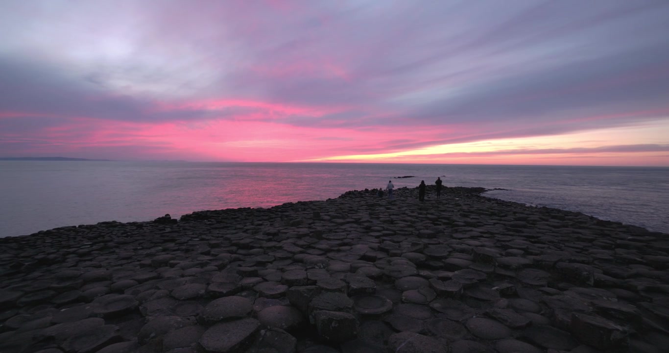 Panoramica di turisti che si dirigono verso la punta del Selciato del Gigante al tramonto