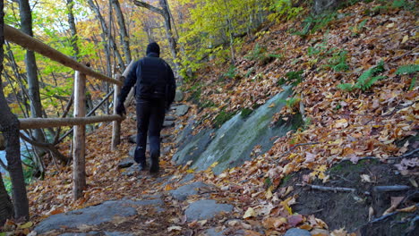 man walking on mountain trail autumn