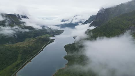 aerial view above moving clouds at fjords and mountain landscape in lofoten islands norway - 4k