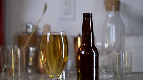 golden beer in a craft beer glass with bubbles and beer bottle next to it