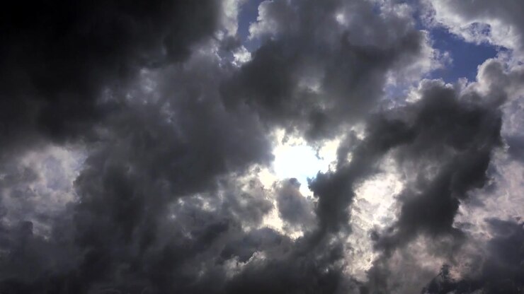 Sollys, der bryder igennem mørke stormskyer på himlen