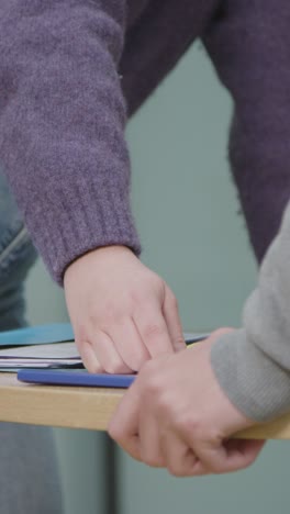 vertical shot of students hands as they work on group project