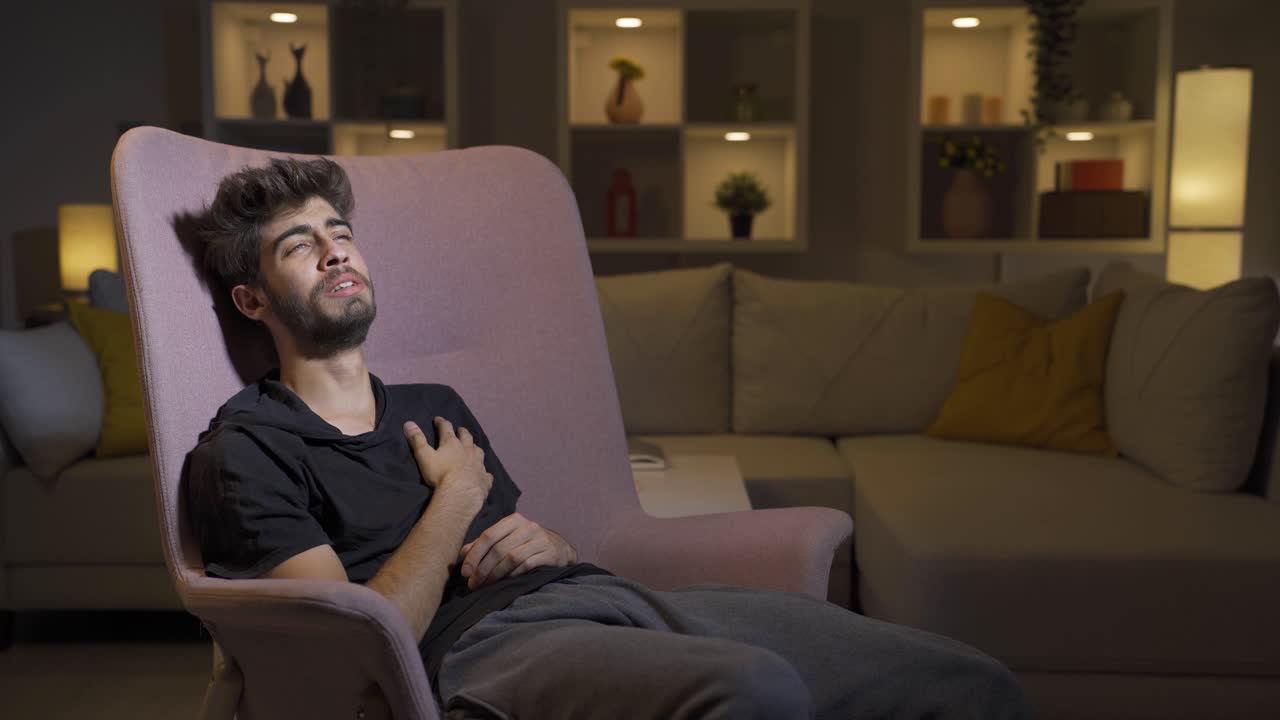 el hombre acostado en el sofá está llorando.