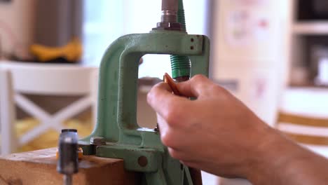 person using single stage reloading press to insert bullet to cal 3006 rifle brass casing - reloading of ammunition process at home