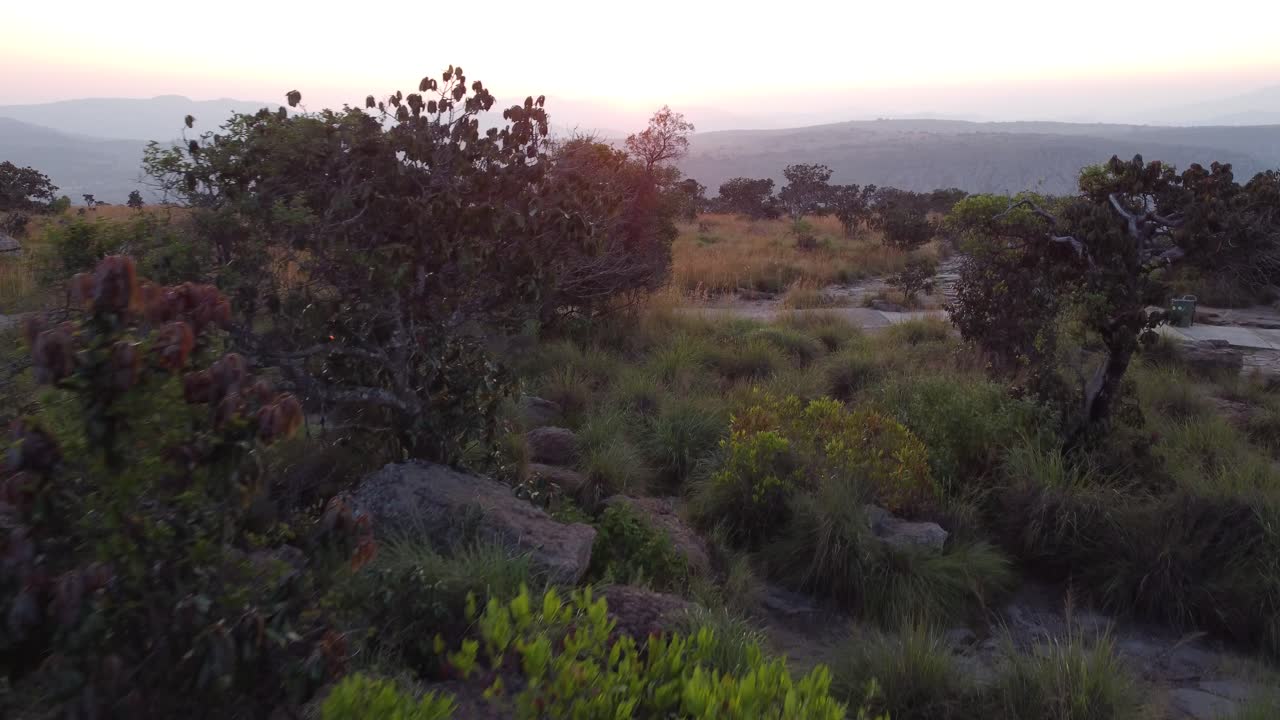 Carrellata aerea in avanti che rivela la catena montuosa del Drakensberg in Sudafrica con il sole sullo sfondo