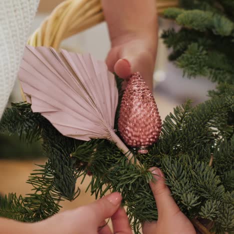 Woman and baby make Christmas wreath from conifers 1