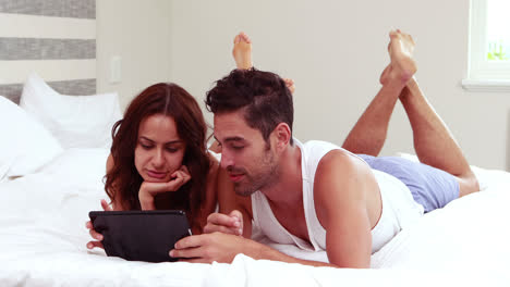 pareja feliz usando la tableta juntos