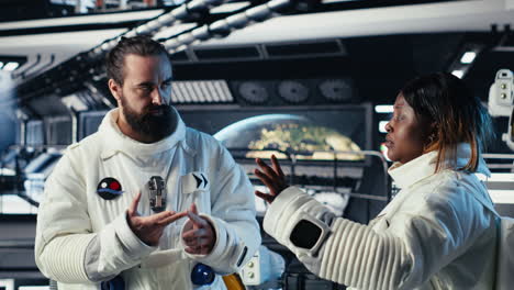 astronauts discussing last details before stepping out outside space station
