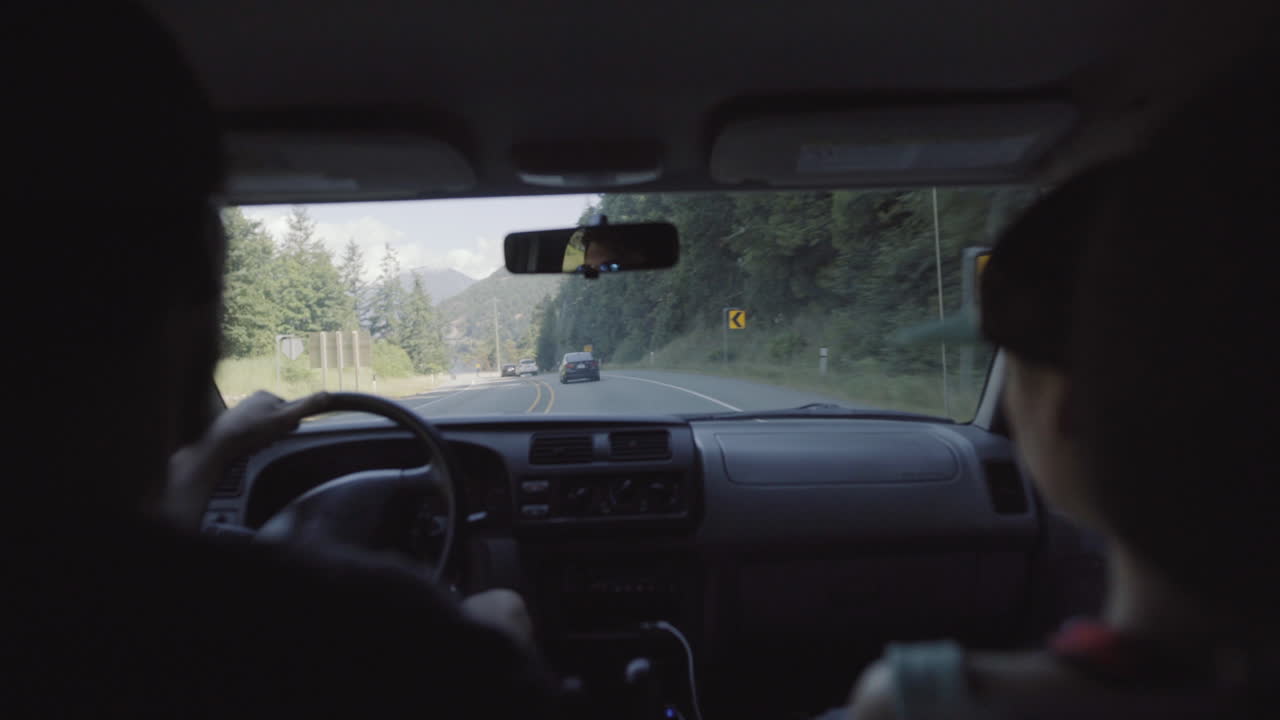hombre y mujer que viajan en coche vista desde el asiento trasero