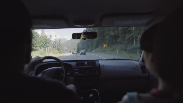 Man and woman traveling by car view from backseat