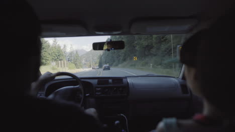 Man-and-woman-traveling-by-car-view-from-backseat