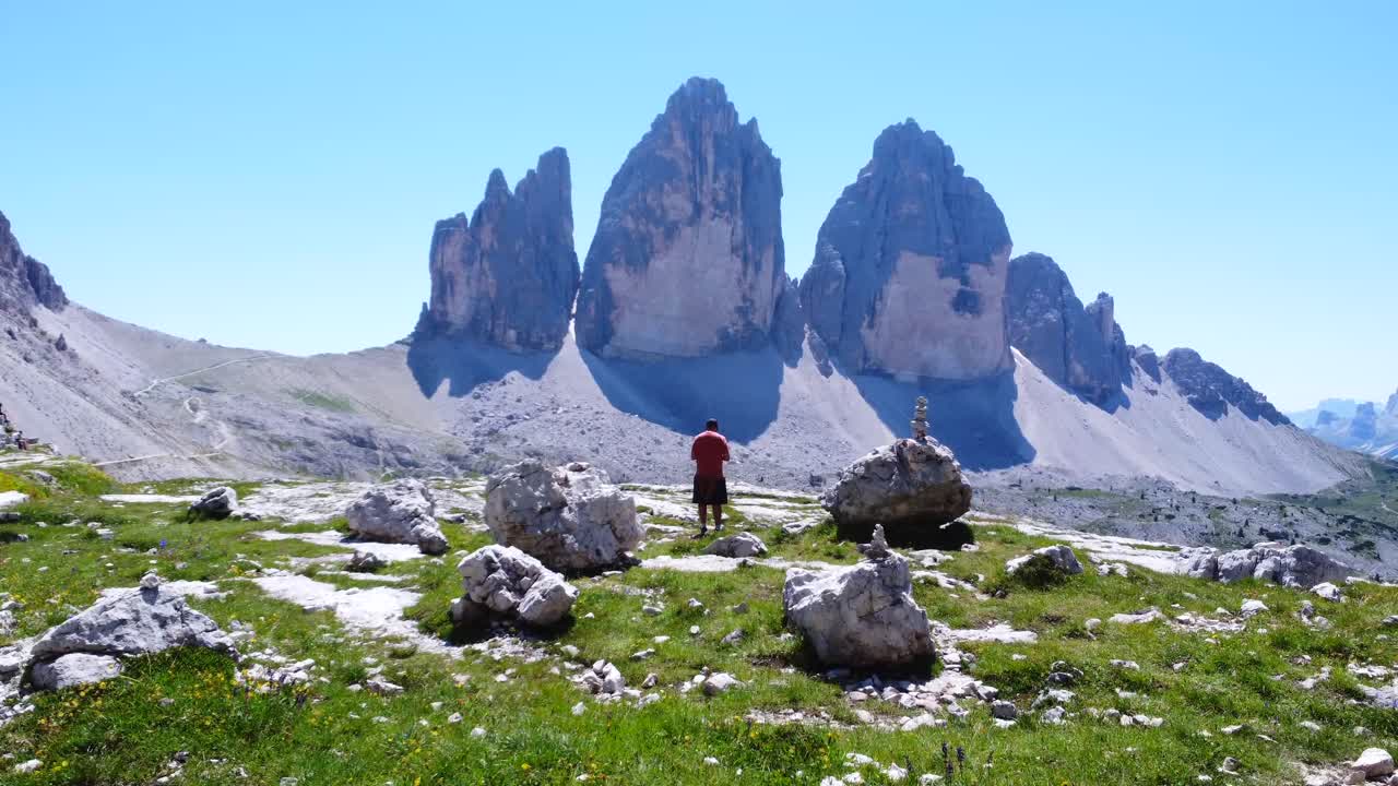 Turisti vaeltaa Tre Cime di Lavredossa näyttäen peukkua kesällä