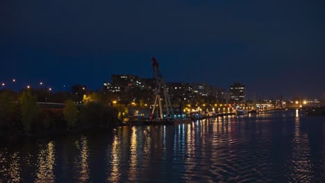 beautiful city lights reflecting in the river along the shore. view from moving boat at night.