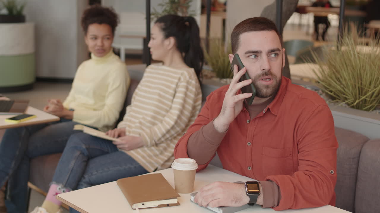 Man Talking on Phone in Restaurant