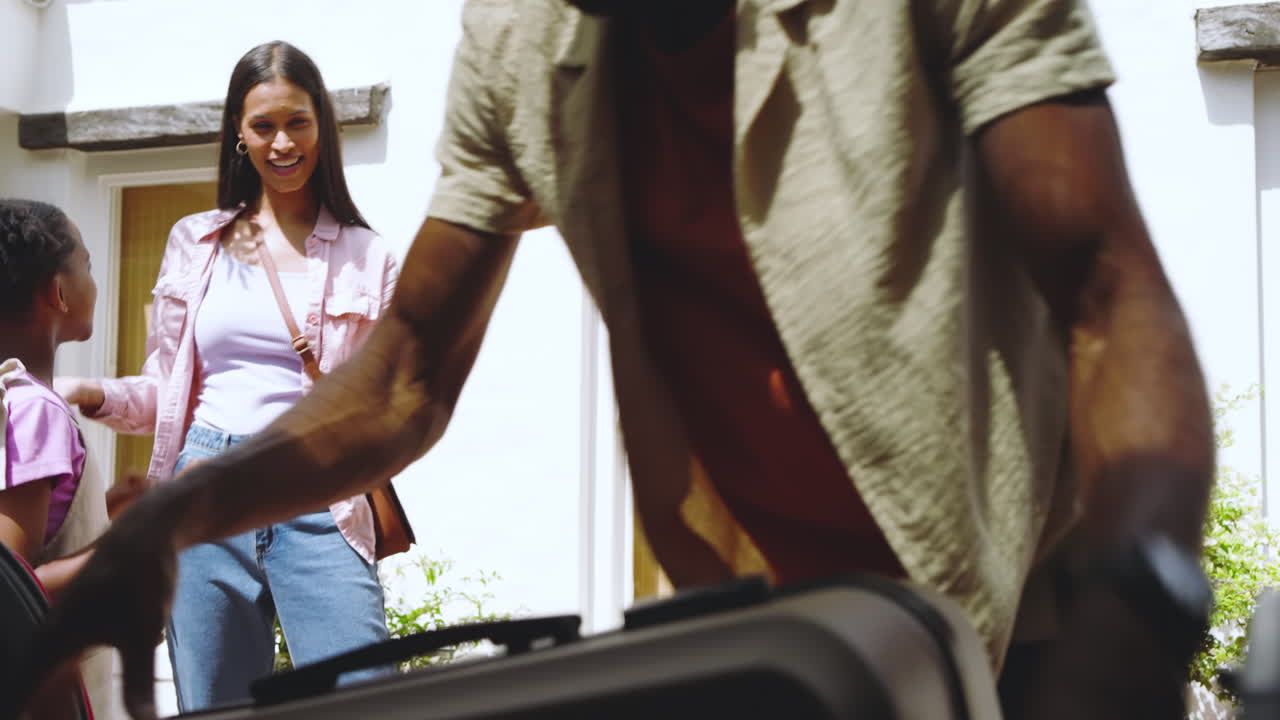 Diverse family packing car for vacation, parents and daughter excitedly preparing together