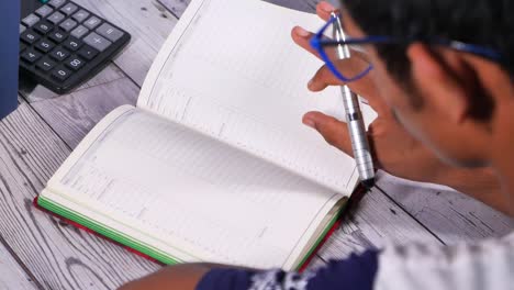 persona escribiendo en un cuaderno en un escritorio
