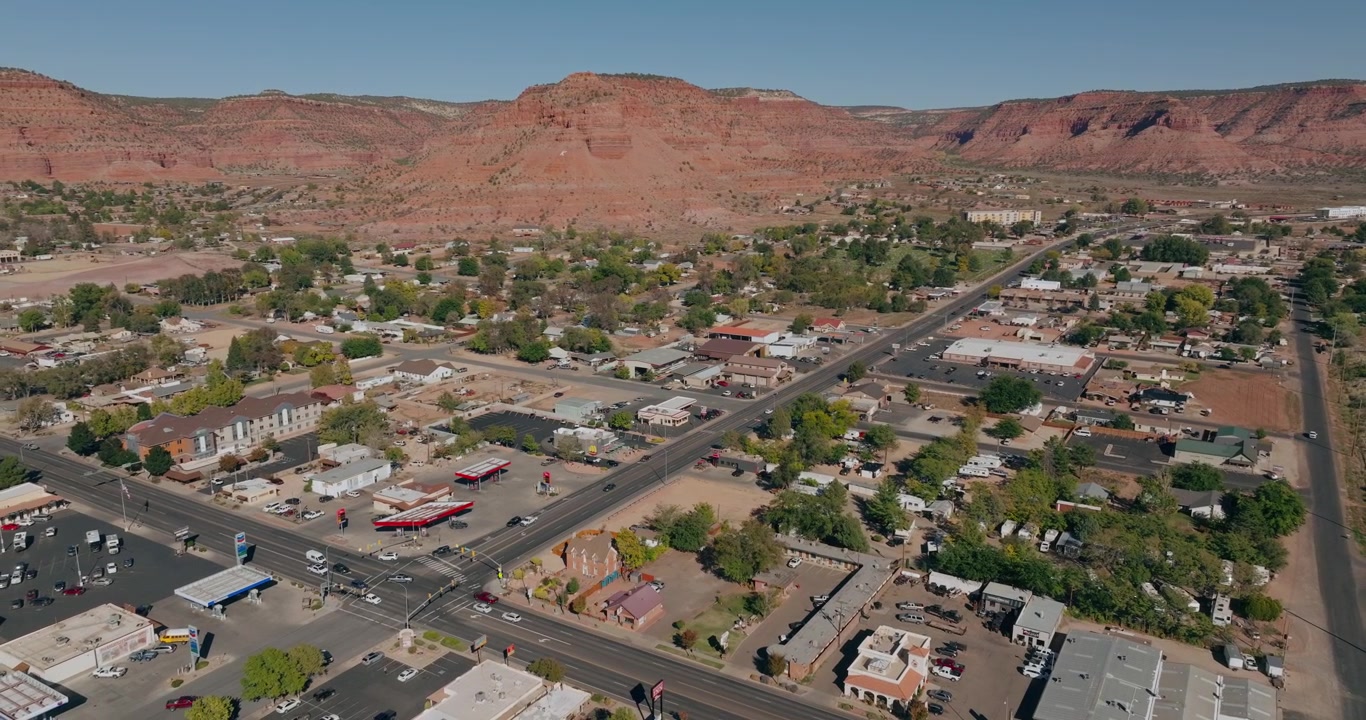 Incrocio nella città di Kanab, Utah, con case e attività commerciali sotto mesas di arenaria rossa, vista orbitale
