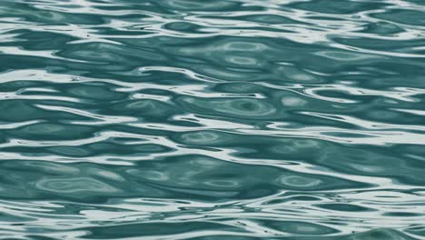 calm ocean waves ripple softly under natural light in phuket, thailand. the camera captures the serene movement of water