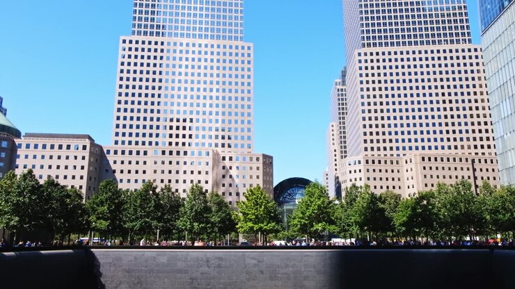 Gente caminando cerca de la fuente Memorial frente al One World Financial Center en Nueva York