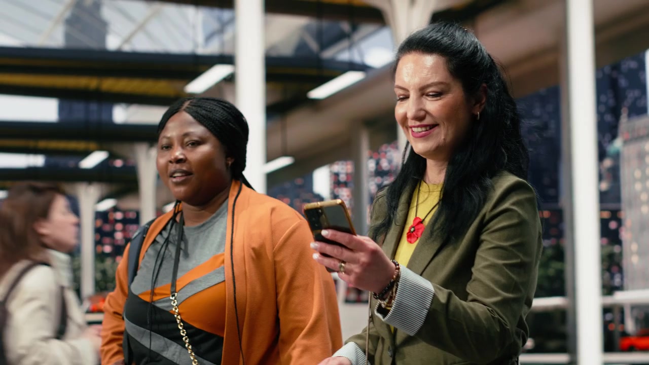 Travel companions in bus station use smartphone to confirm trip details