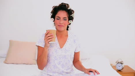 mujer alegre con rizos de cabello disfrutando de café