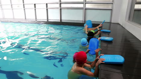 swimming coach teaching children how to swim