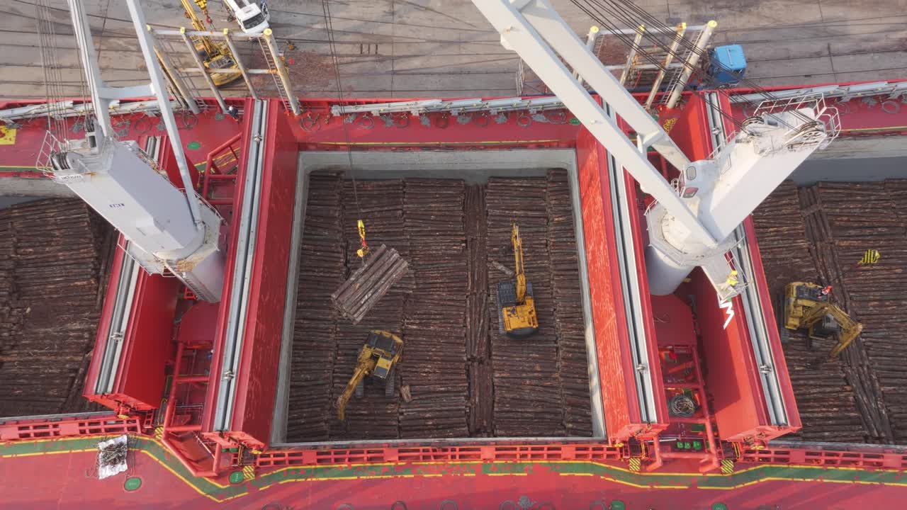 우루과이 강을 따라 화물 선박이 크레인과 발굴기와 함께 목재를 고 있습니다.