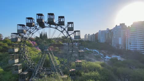 하늘에서 빛나는 태양과 함께 낮에 파르케 사르미엔토의 언덕 꼭대기 전망대로 이어지는 vuelta al mundo de cordoba 관람차와 랜드마크 계단을 캡처하는 공중 패닝 뷰
