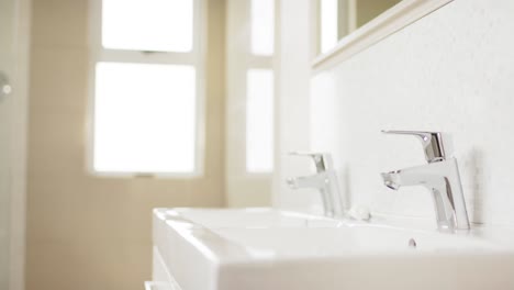 close up of basin and chrome taps in bathroom, slow motion