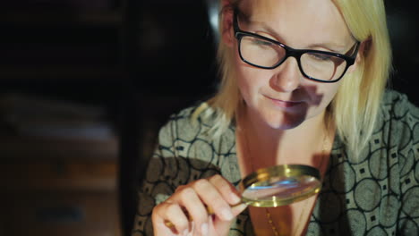 woman uses magnifying glass